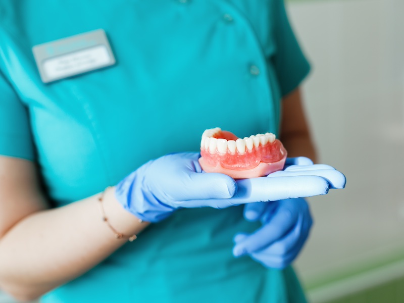 Dental hygienist holding a denture model
